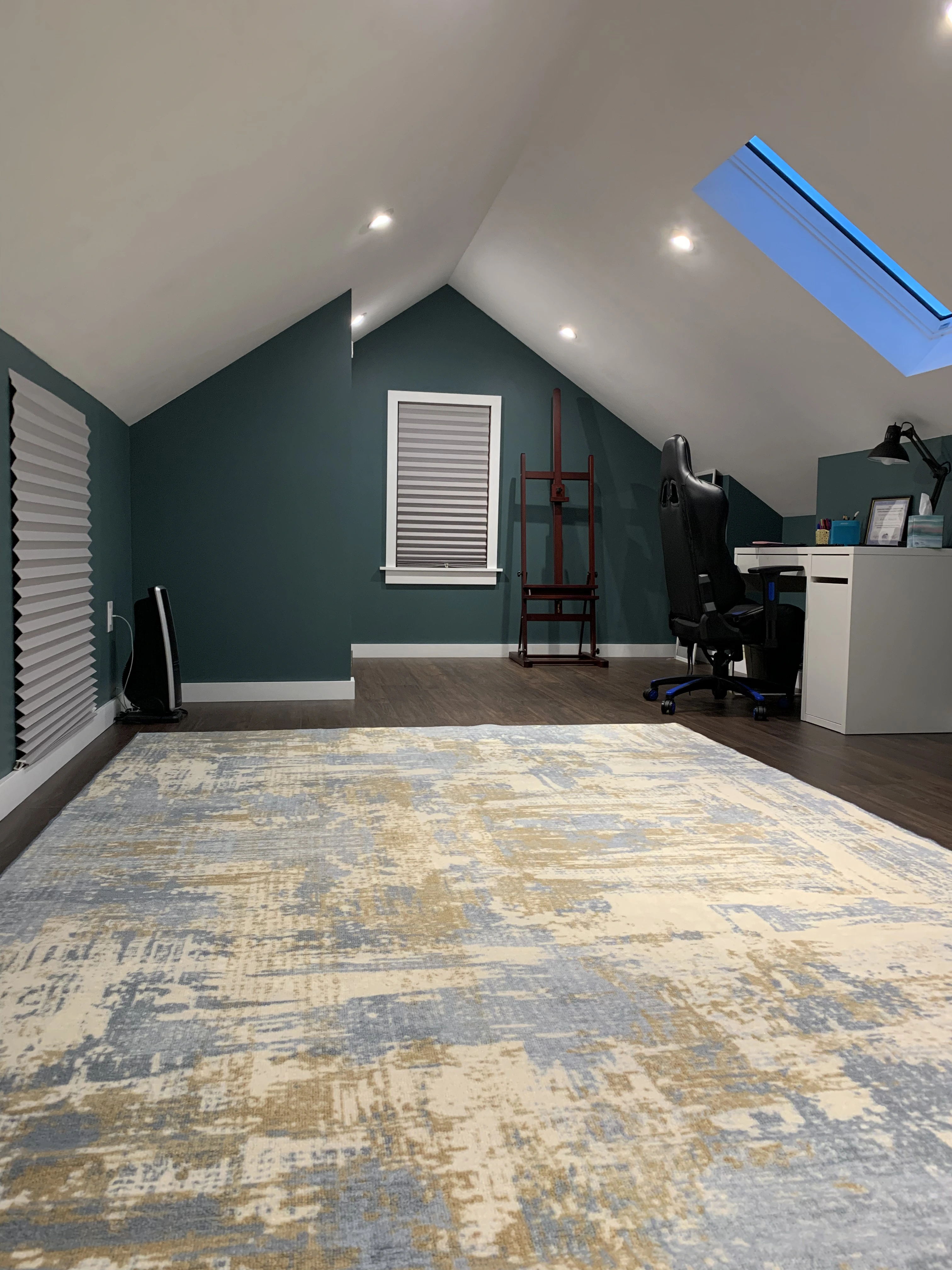 A finished attic which includes a skylight and some furniture to liven the area up