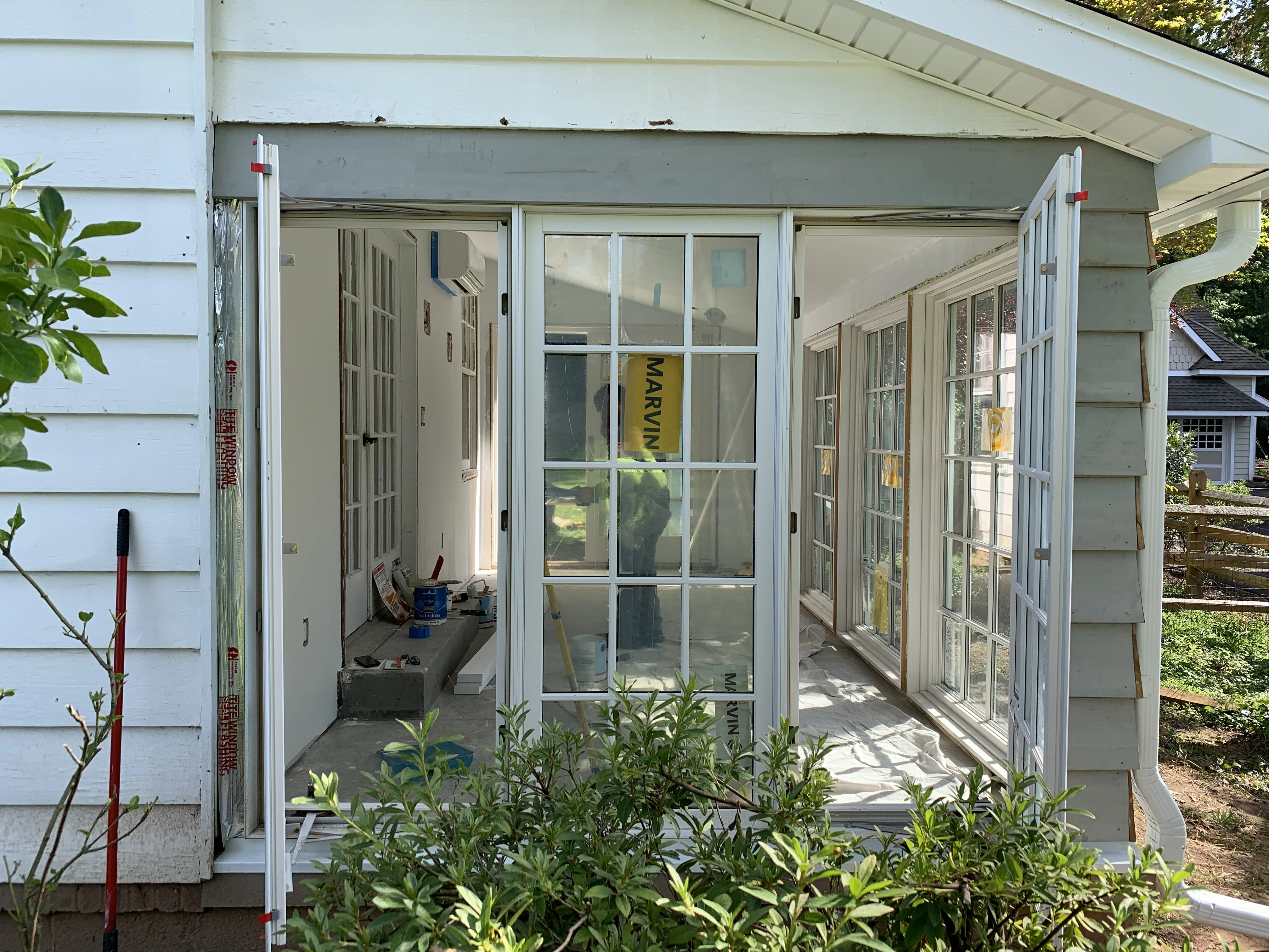 A sunroom renovation from the side view showcasin glass doors being opened