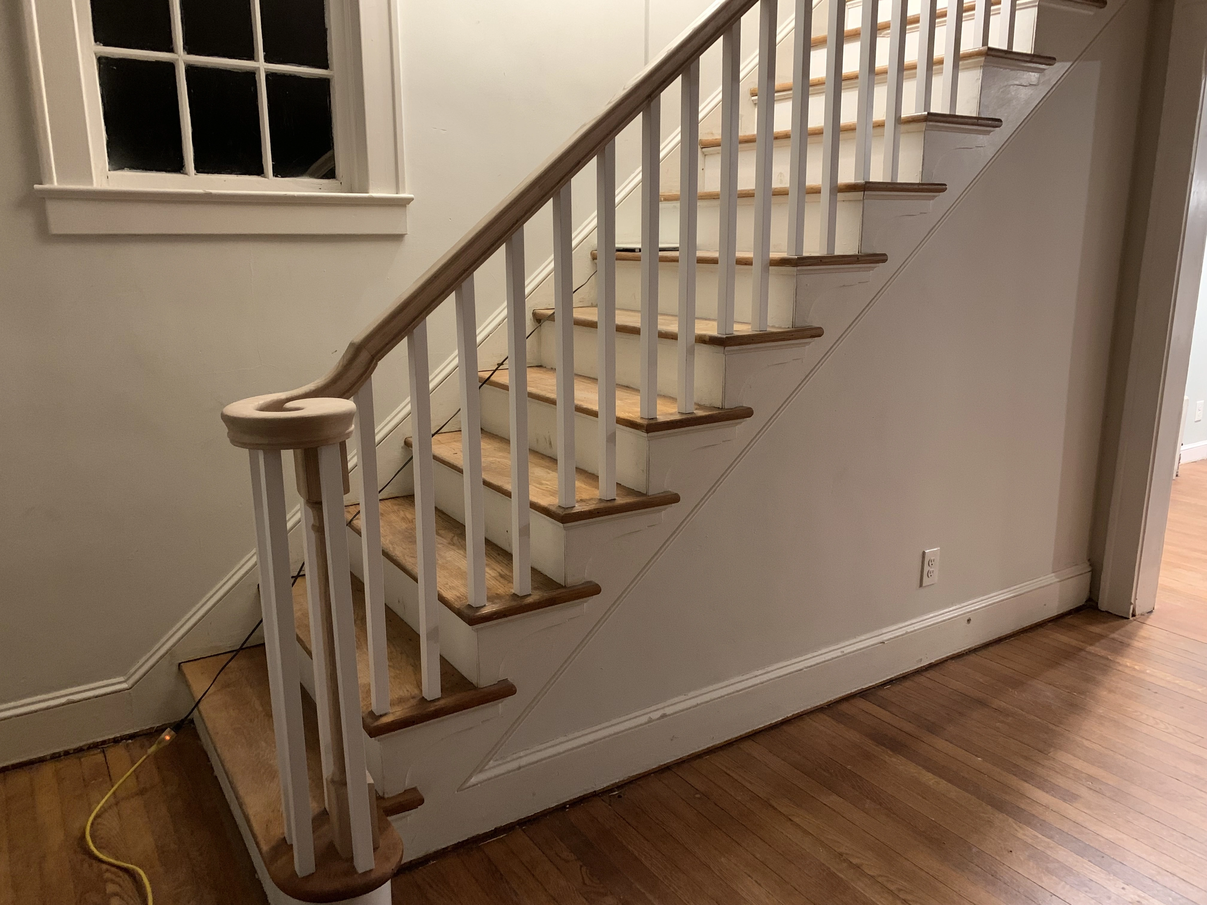 A renovated staircase with new steps and railing